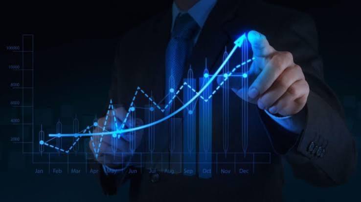 A businessperson pointing at an upward-trending financial chart